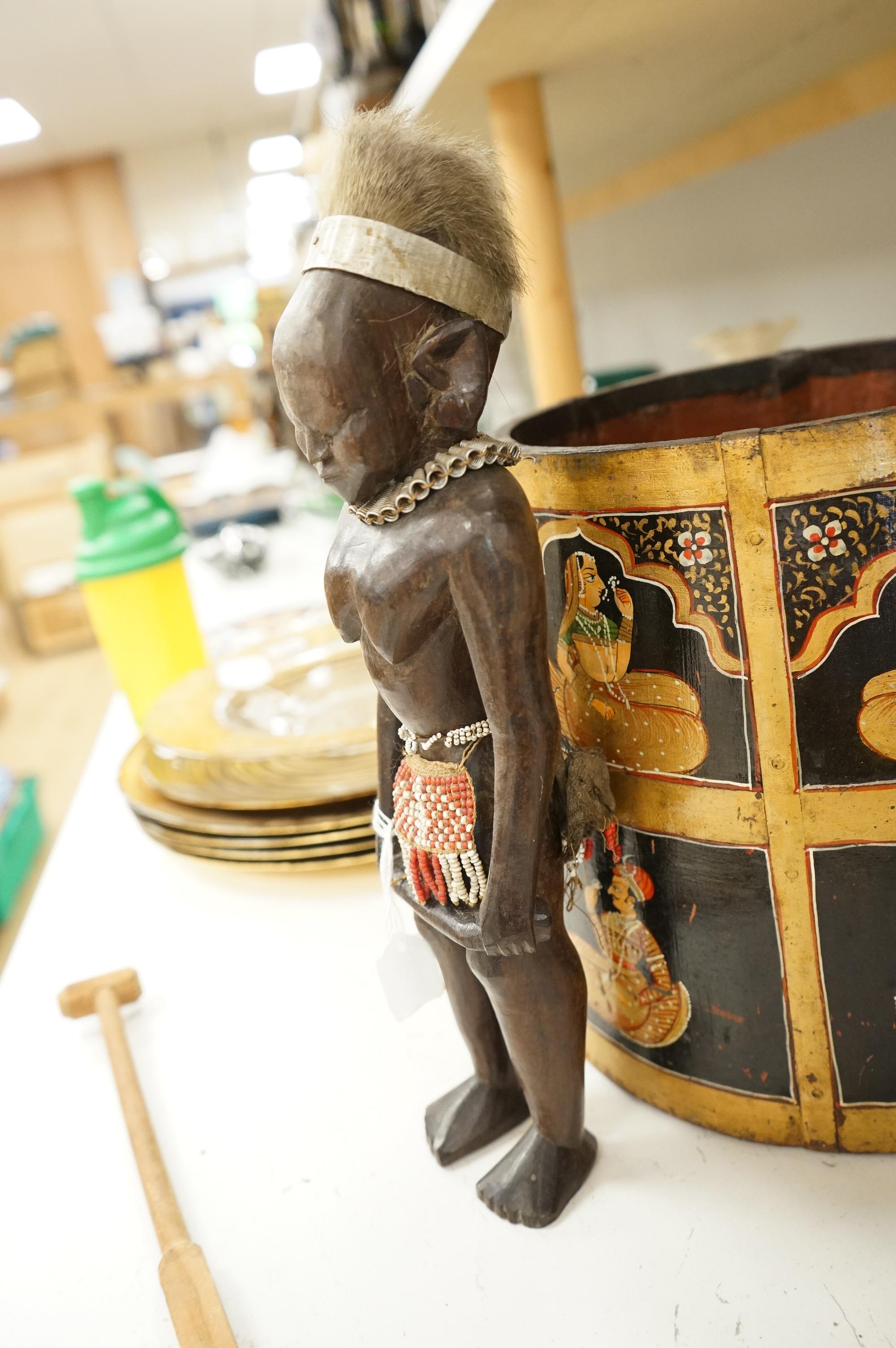 A collection of tribal and Asian collectables including a Tibetan prayer wheel, carvings, etc.